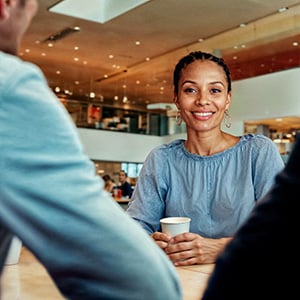 Vrouwelijke medewerker gemeentehuis zit aan tafel met 2 mensen