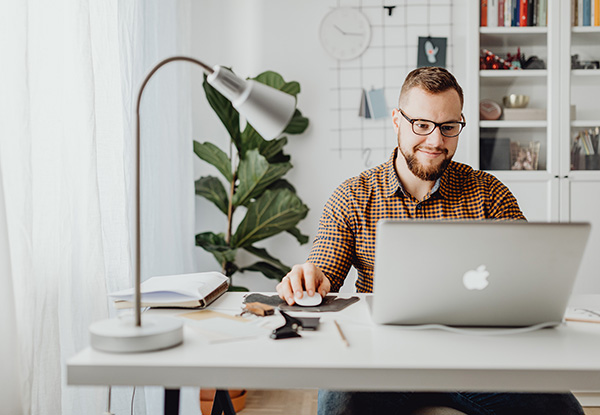 Man achter laptop aan bureau