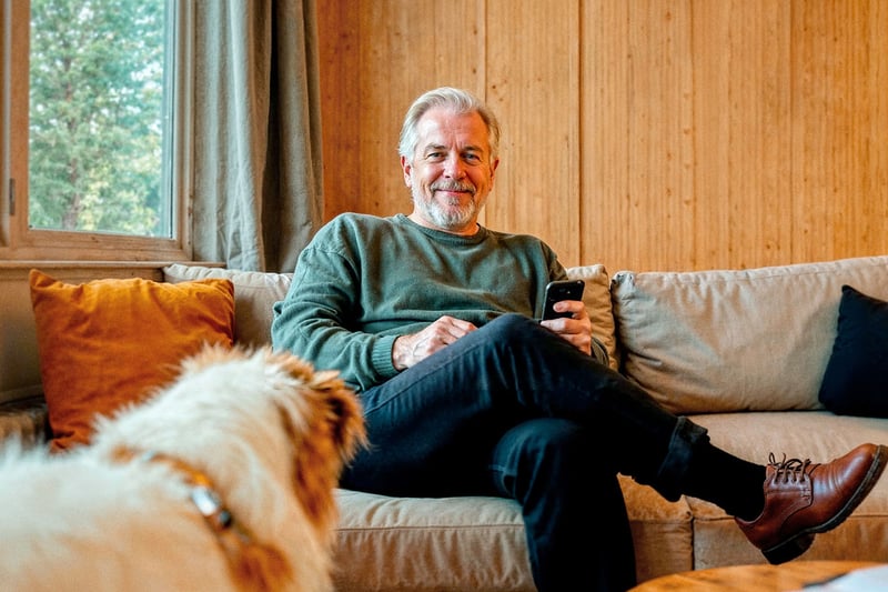 Man op de bank met smartphone in hand