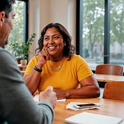 Vrouw zit bij financieel adviseur aan tafel