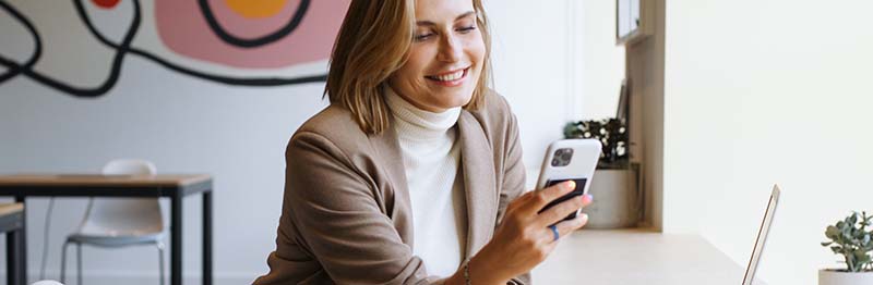 Vrouw smartphone blij: Het is de bedoeling dat elke burger straks zijn EDI kan gebruiken via een app