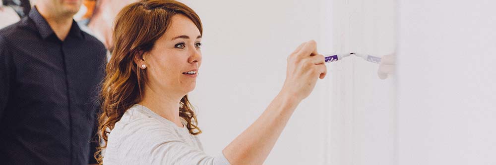 Vrouw schrijft op whiteboard